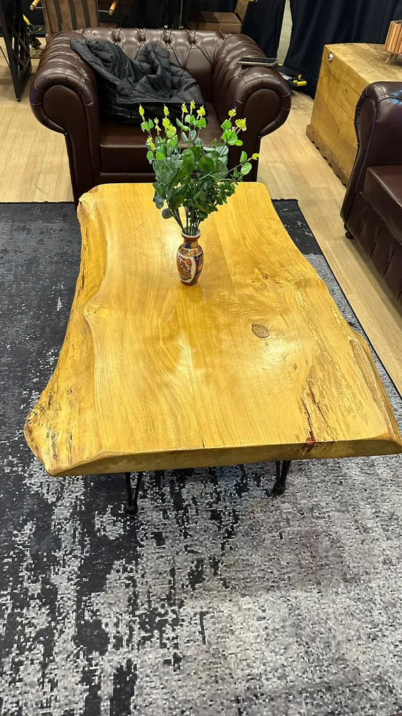 Doğal kenarlı kütük ahşap sehpa ve Chesterfield koltuk detayı
