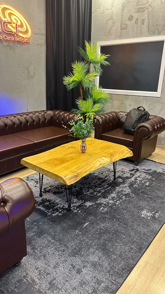 Neon Medya Canlı logosu altında Chesterfield koltuklar ve kütük sehpa ile dikey çekime uygun podcast seti